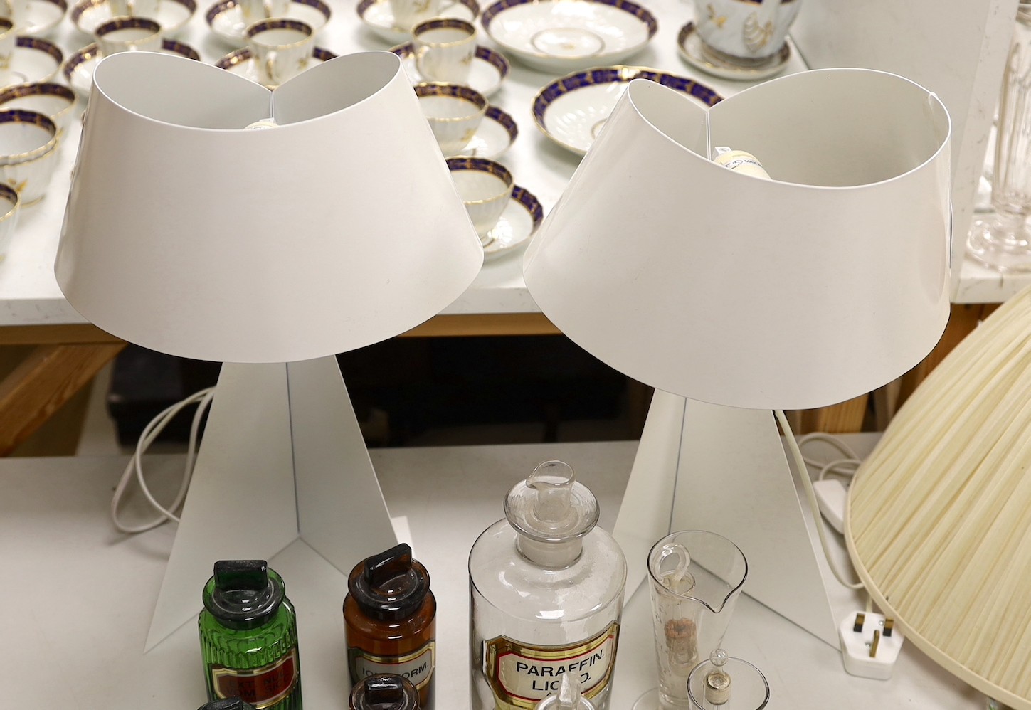Two white painted metal sculptural table lamps, 48cms high